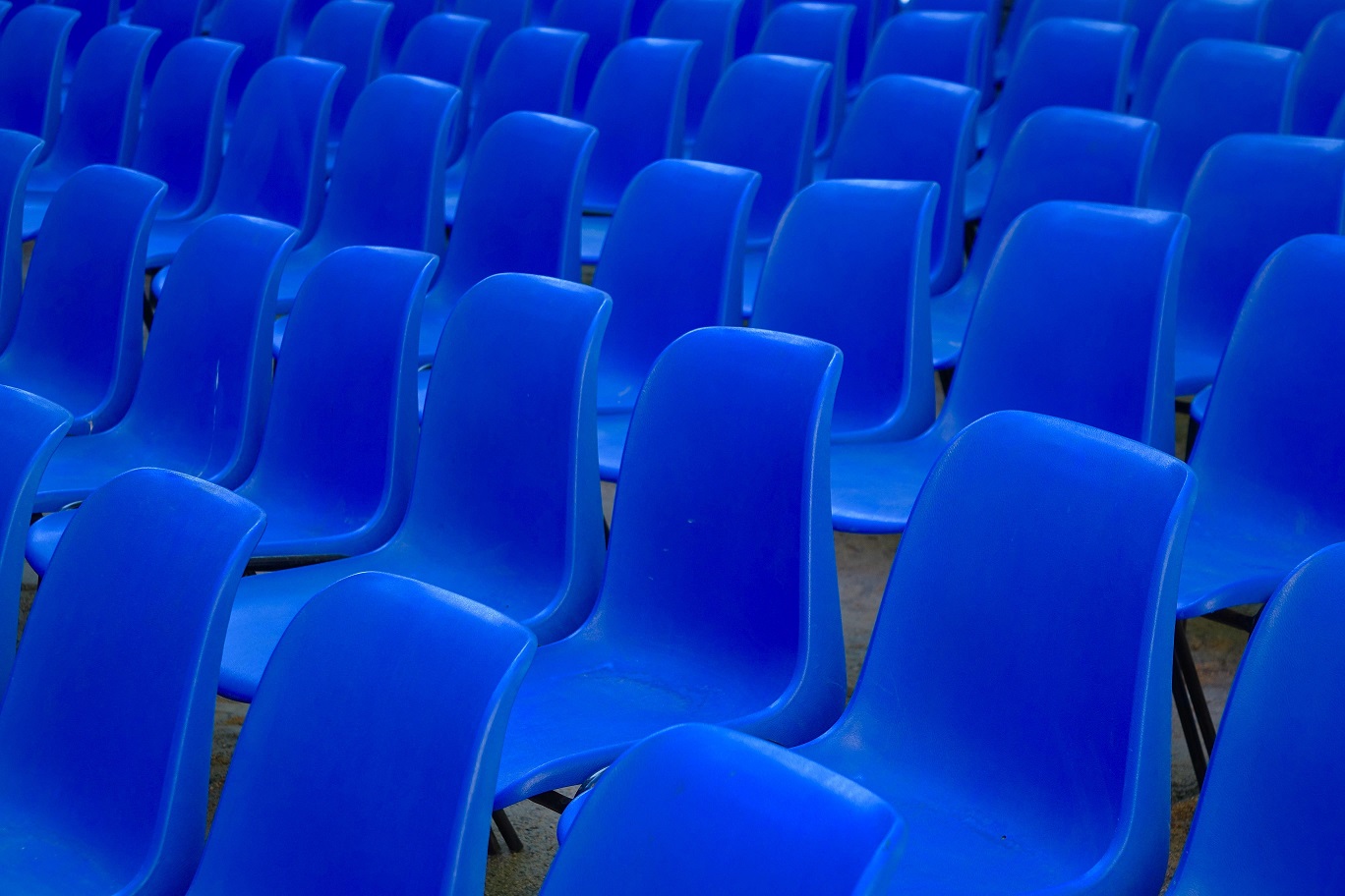 rows of empty blue plastic chairs
