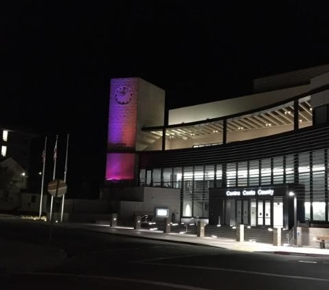 Contra Costa Admin building at night with purple light on clock tower