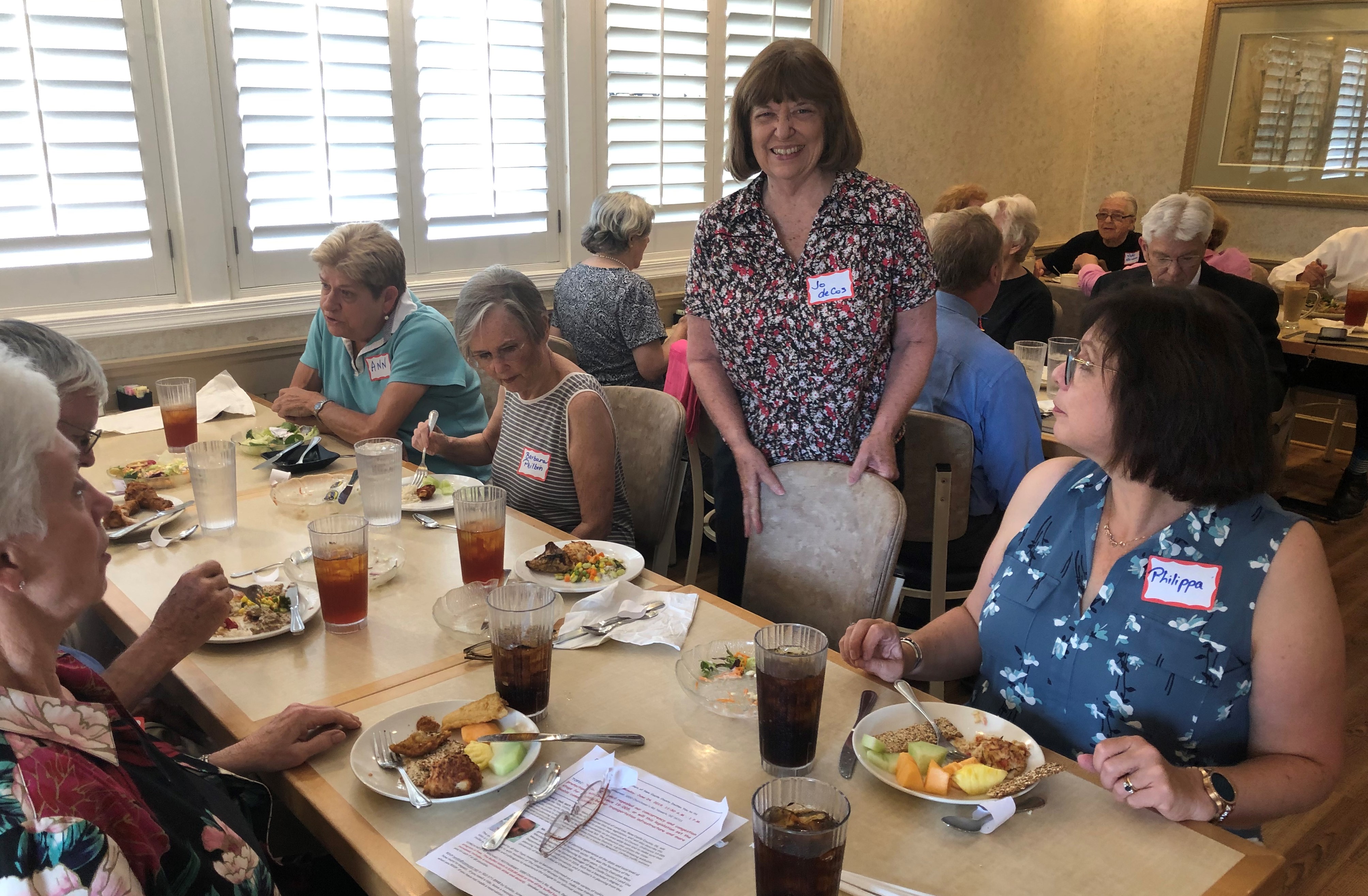 Tables, chairs, lunch plates, diners, smiling faces