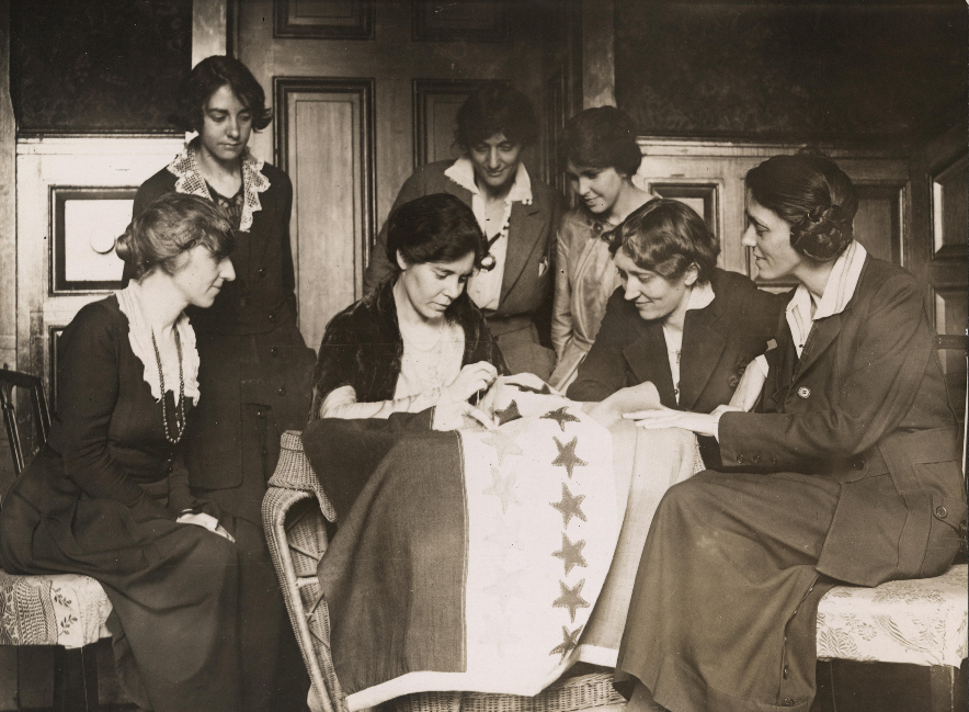 Alice Paul sewing a star on the suffrage flag