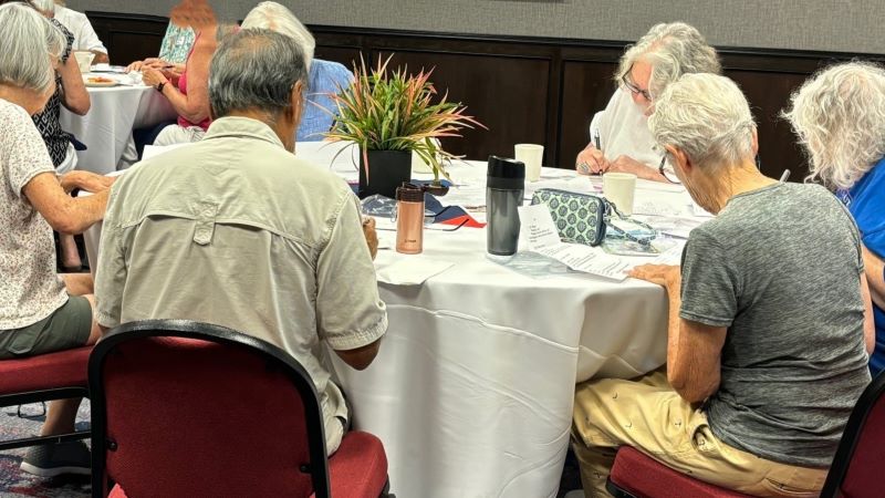 Image by LWVOC member Photo of Group Writing Postcards