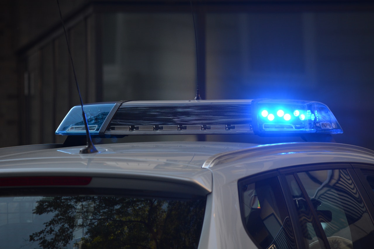 Blue light flashing on top of white emergency vehicle