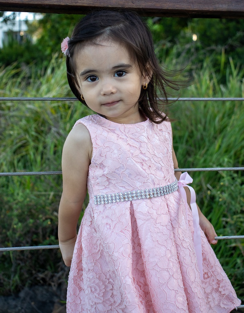 young girl in pink dress with wistful expression