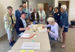 LWVHC volunteers around a table smiling and counting votes