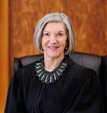Woman in black judicial robe smiles at camera