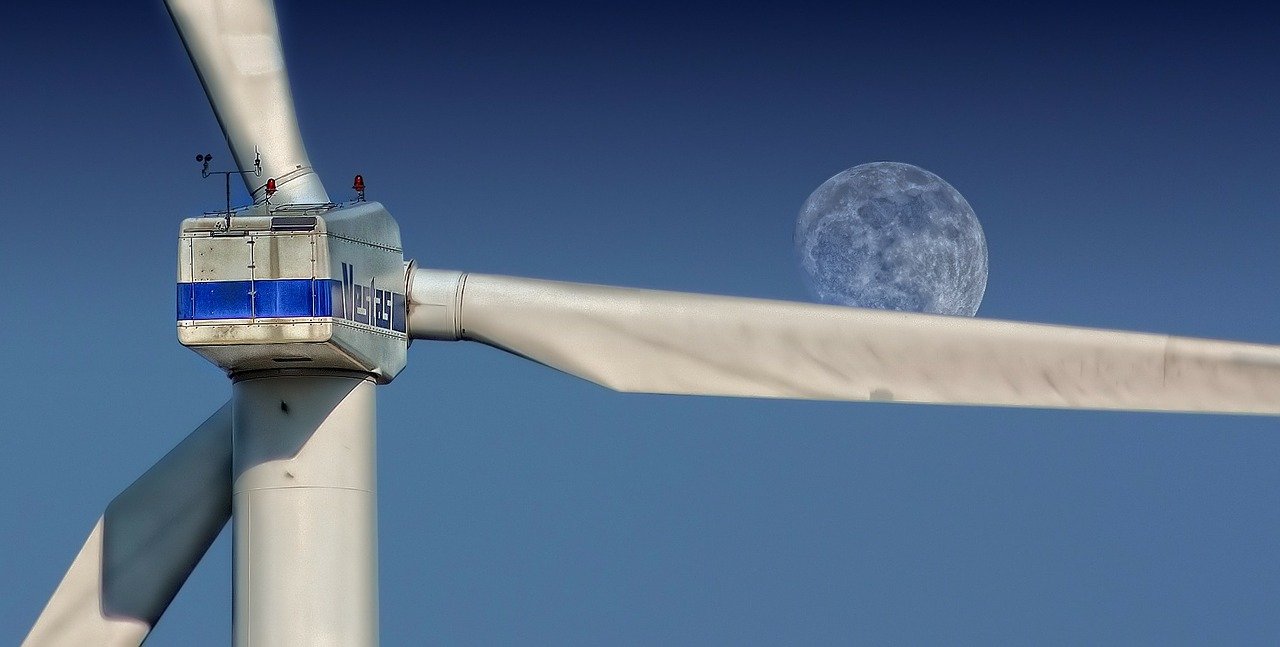Windmill blades with moon in background