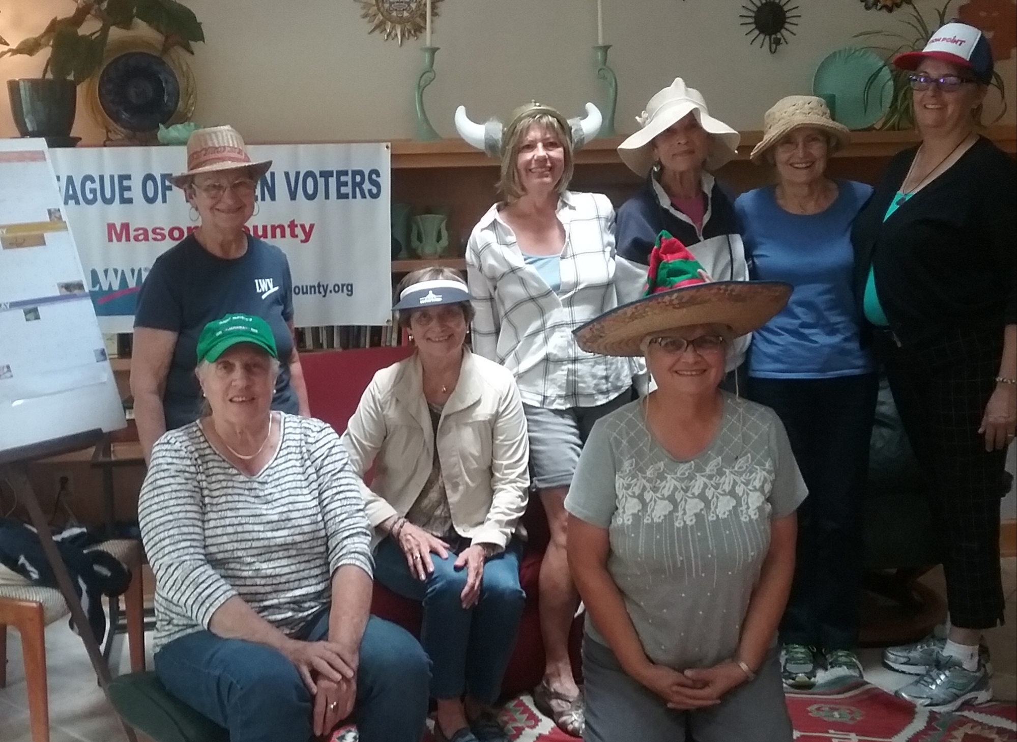Mason County Board Members at a board retreat don a variety of hats to signifying the many hats they wear, the roles they have taken on, as League board members.