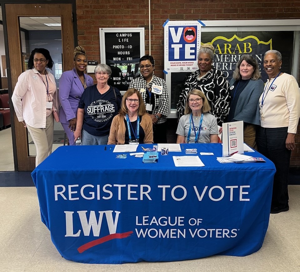 Several women pose at voter registration event