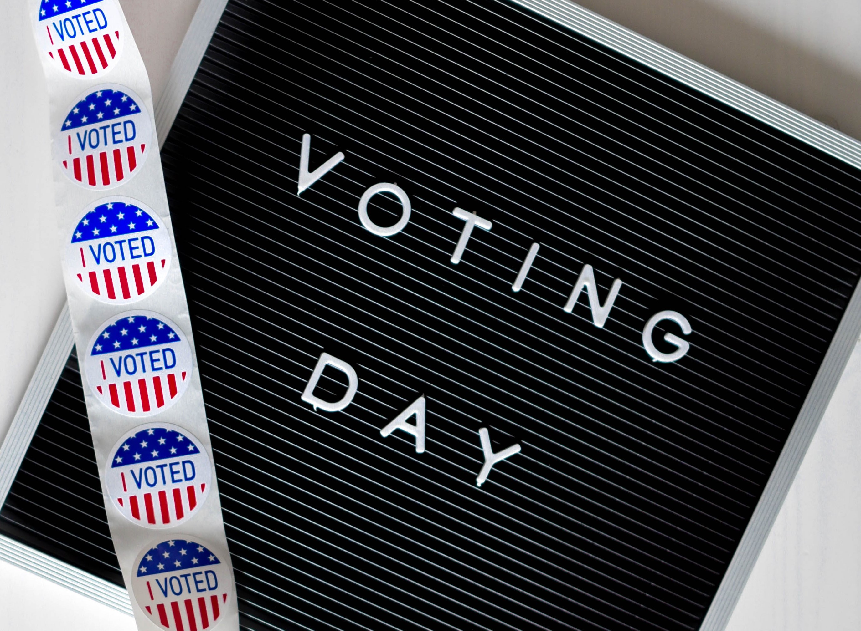 Voting Day letterboard with strip of "I VOTED" stickers draped over letterboard