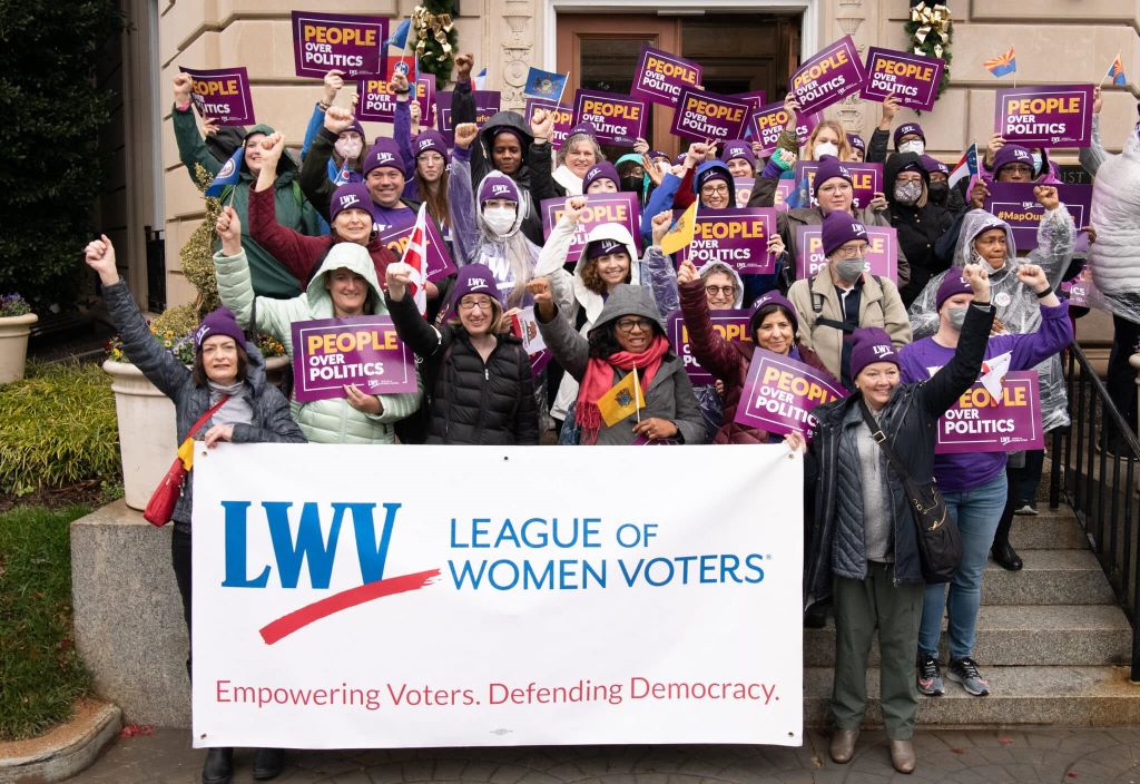 crowd of people outdoors holding LWV signs