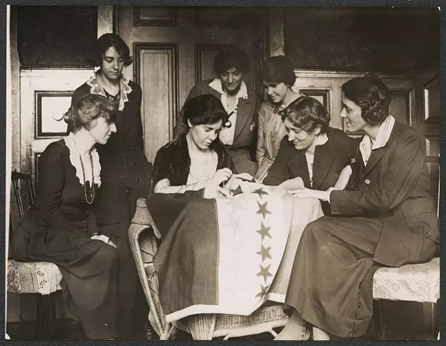 women sewing a star on a banner for nps