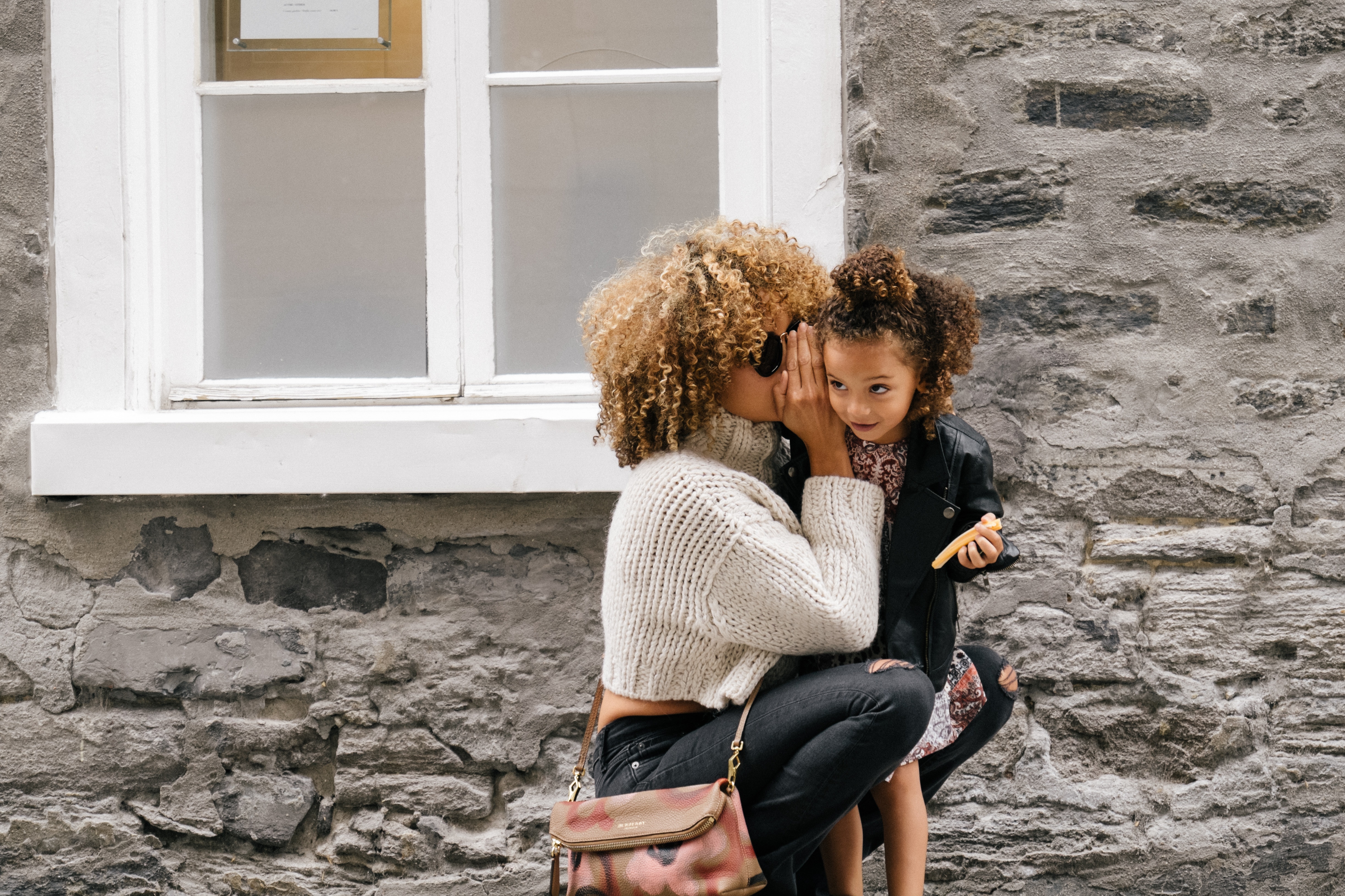 Photo of mother whispering to child