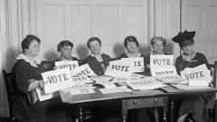 Vintage LWV members holding "Vote" signs 