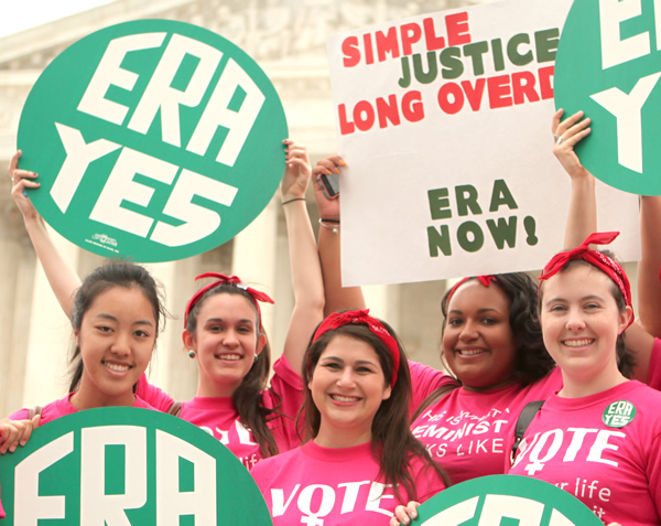 Women in pink T-shirts raising ERA YES signs