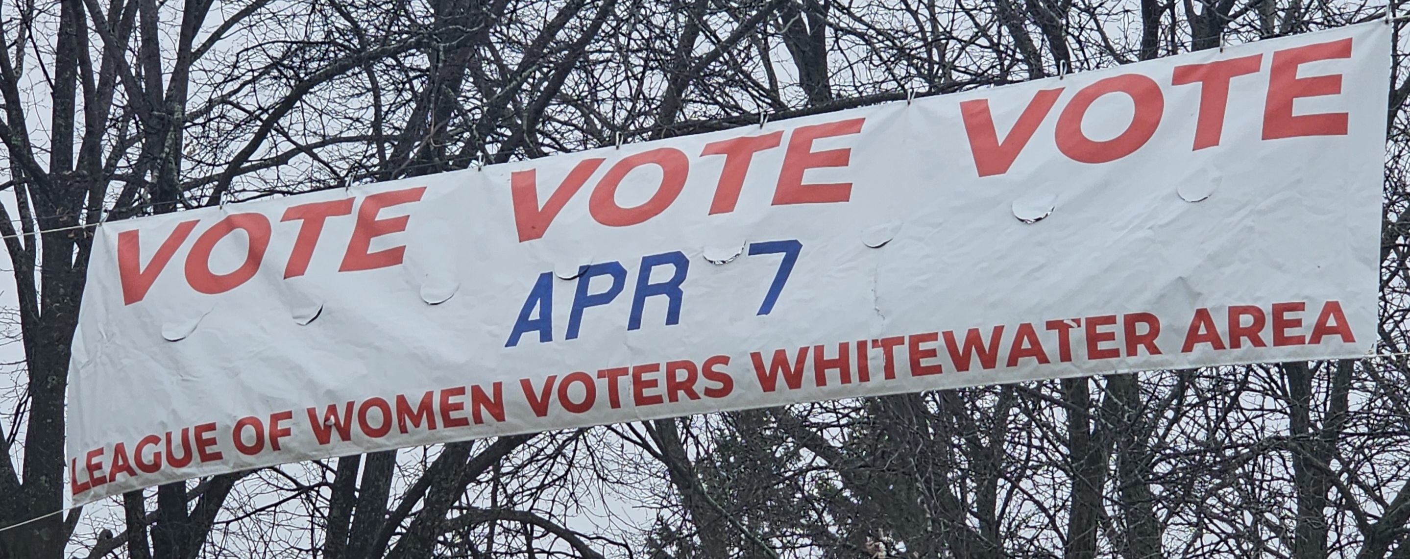 Street banner reading "VOTE VOTE VOTE Apr 7"