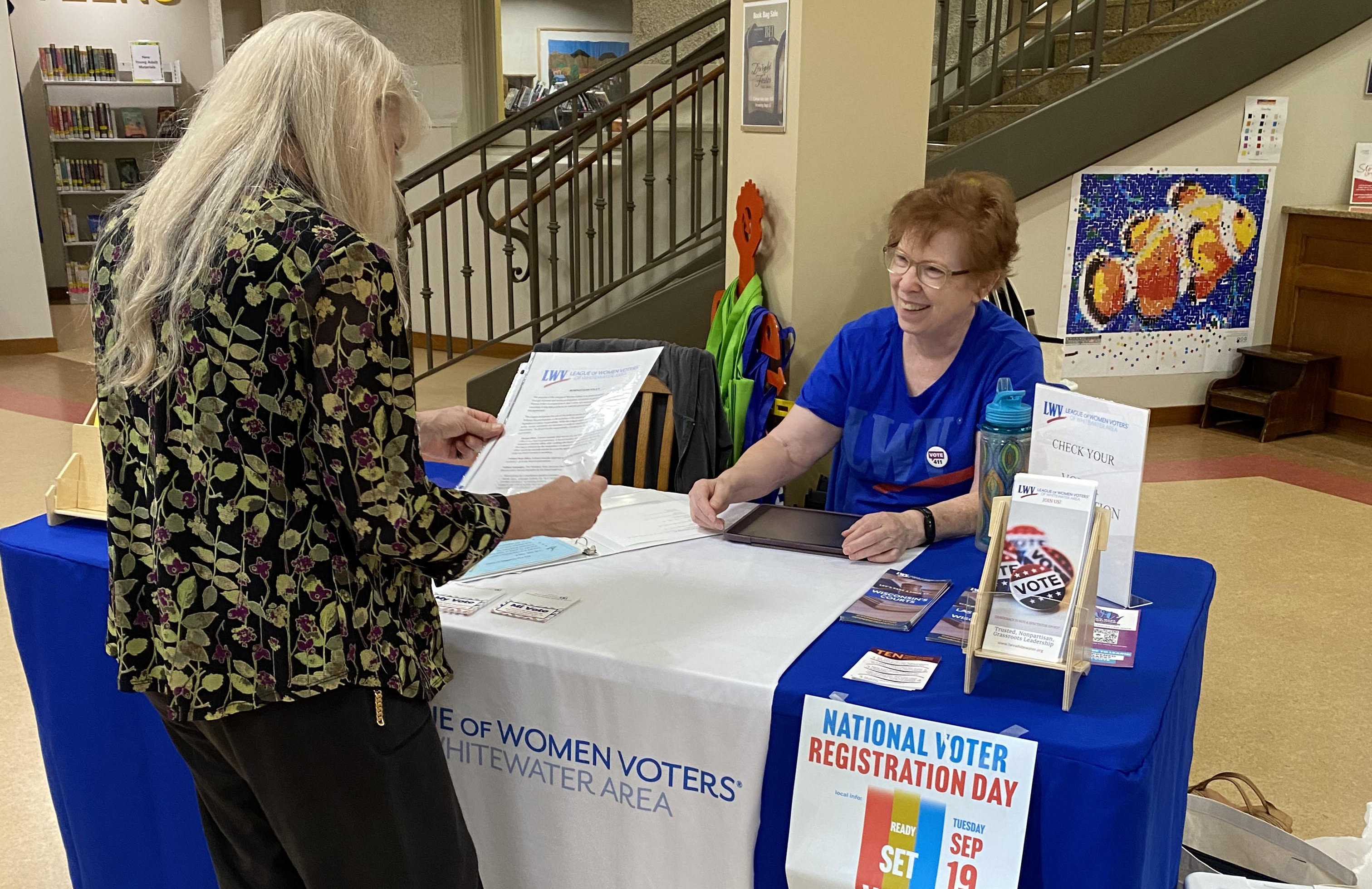 President Midge Gill offers voter information to Whitewater Area Citizen