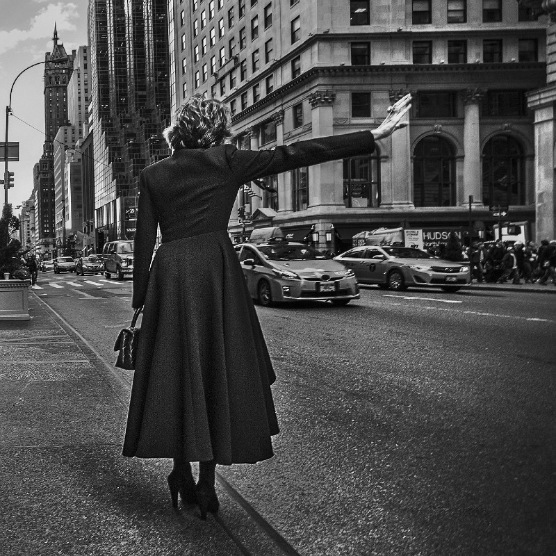 Woman hailing cab, black and white photo