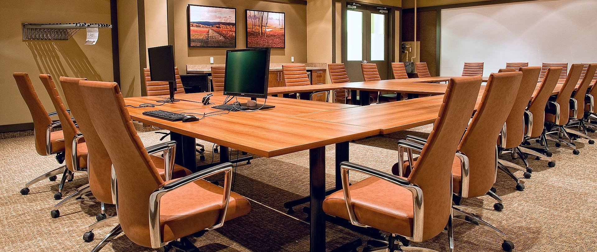 Boardroom with table, chairs, open computer