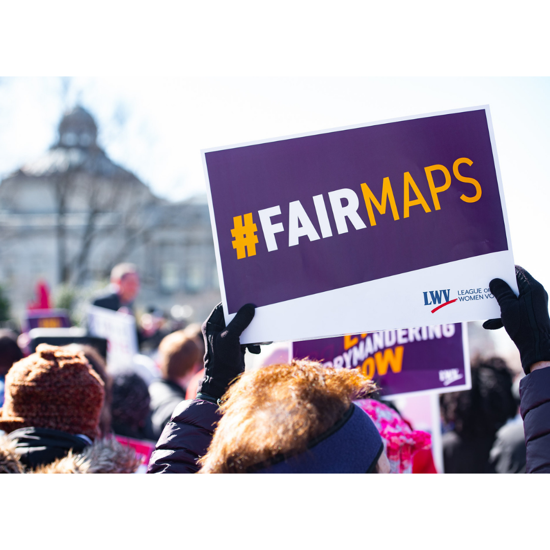 woman holding fair maps sign