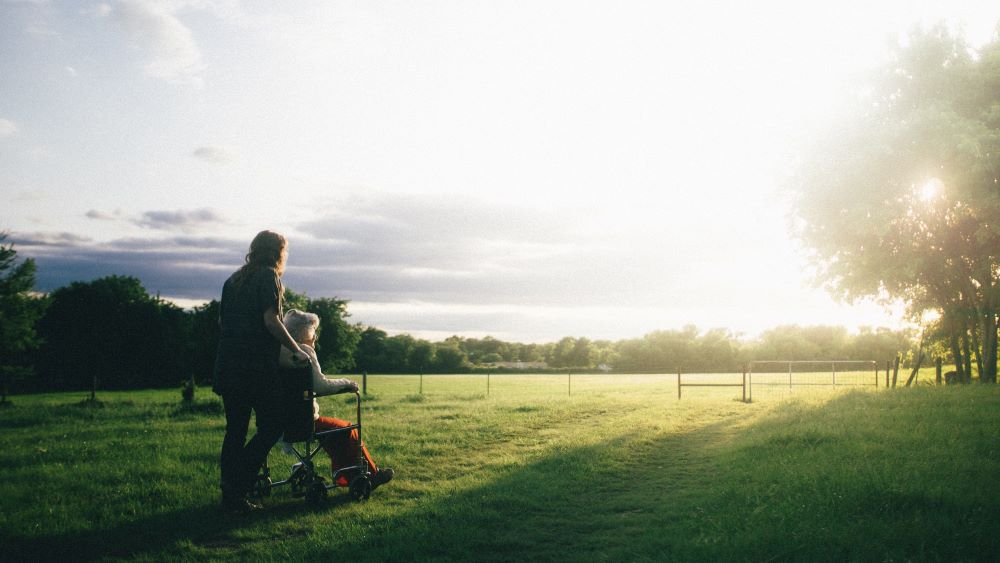 Photo by Dominik Lange on Unsplash Woman in wheelchair assisted by woman caregiver
