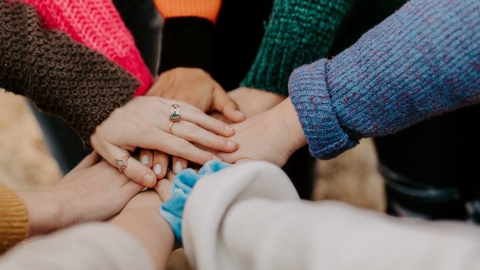 Photo of Women's Hands in Team Huddle