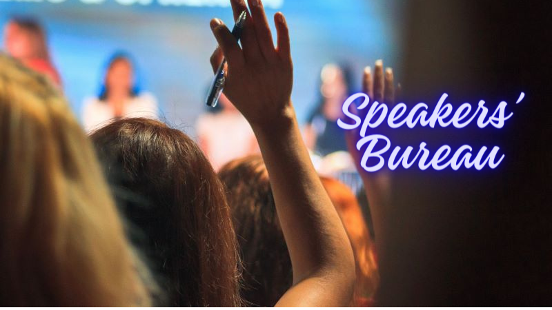 Audience with hands raised Speakers' Bureau