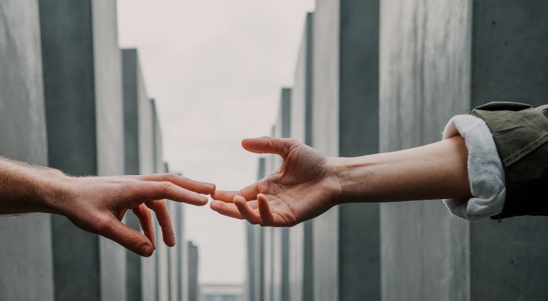 Photo by Toa Heftiba on Unsplash Photo of one person extending a hand to another
