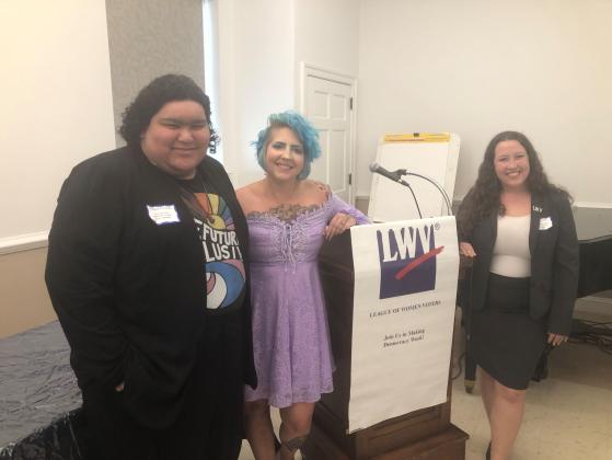 our three keynote speakers are shown next to the podium with LWV banner