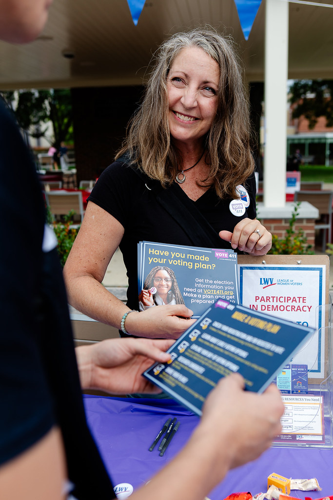 A woman giving out a one-pager on VOTE411 on NVRD