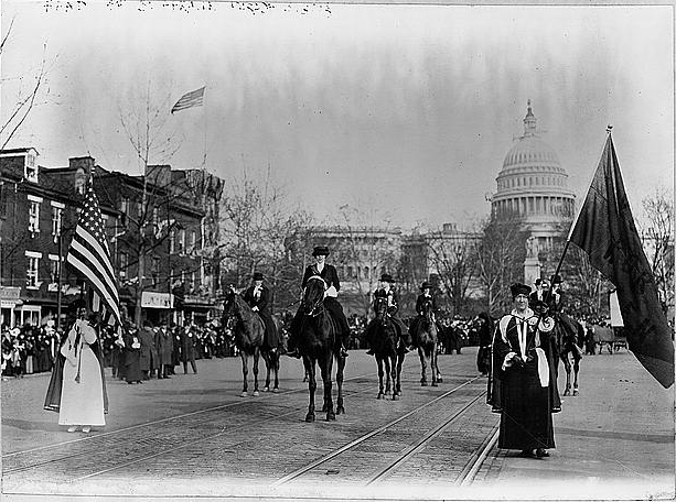  Women suffragists marching on Pennsylvania Avenue in 2013; U.S. Capitol in background