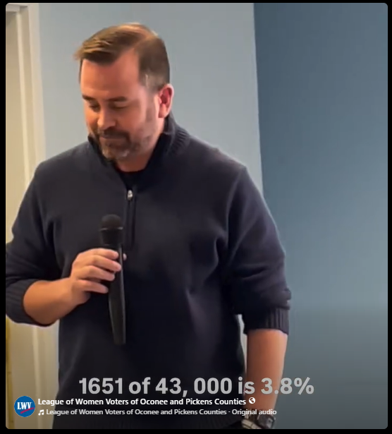 A man holding a microphone with text underneath it