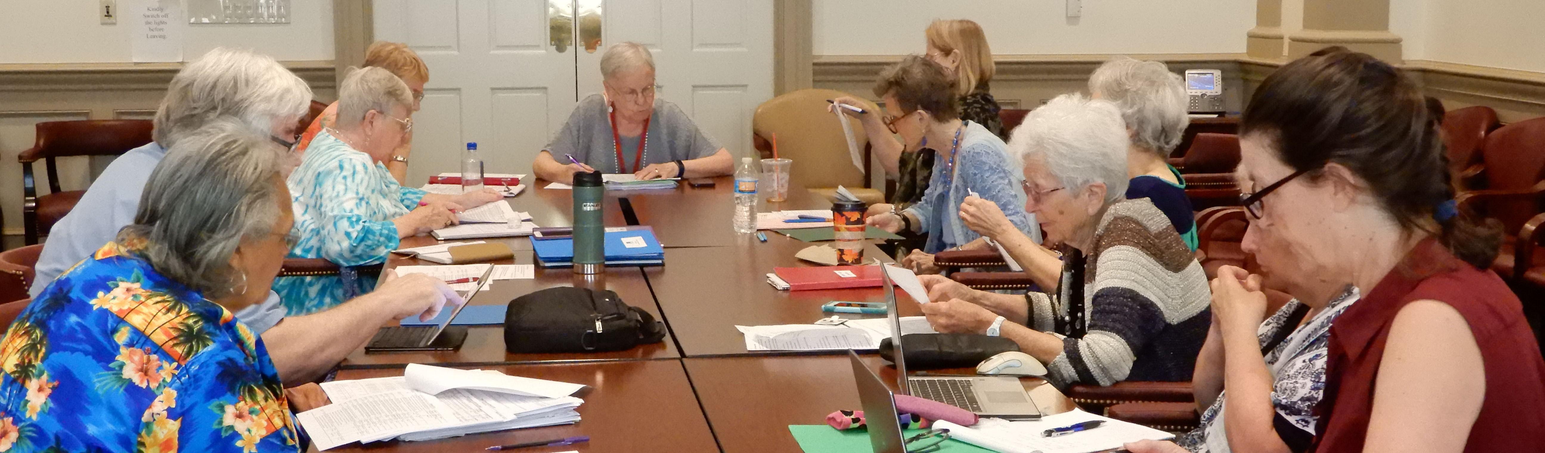 Committee members gathered around a table, working