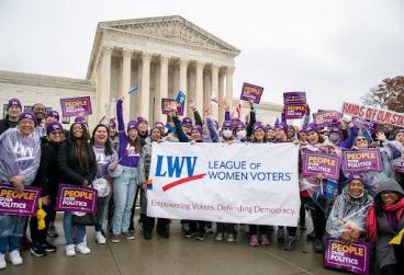 LWV Protest Outside Supreme Court Building - women holding LWV Banner and signs that read People over Politics