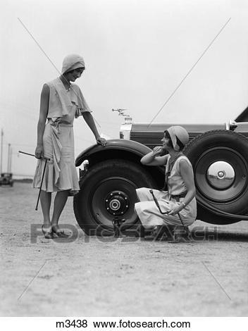 Women fixing tires Photo of women from 1930s repairing car tire