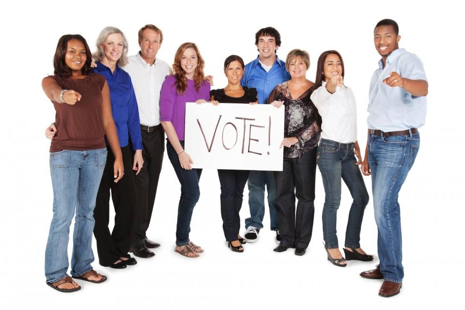 group with vote sign diverse group holds a sign that says "Vote"