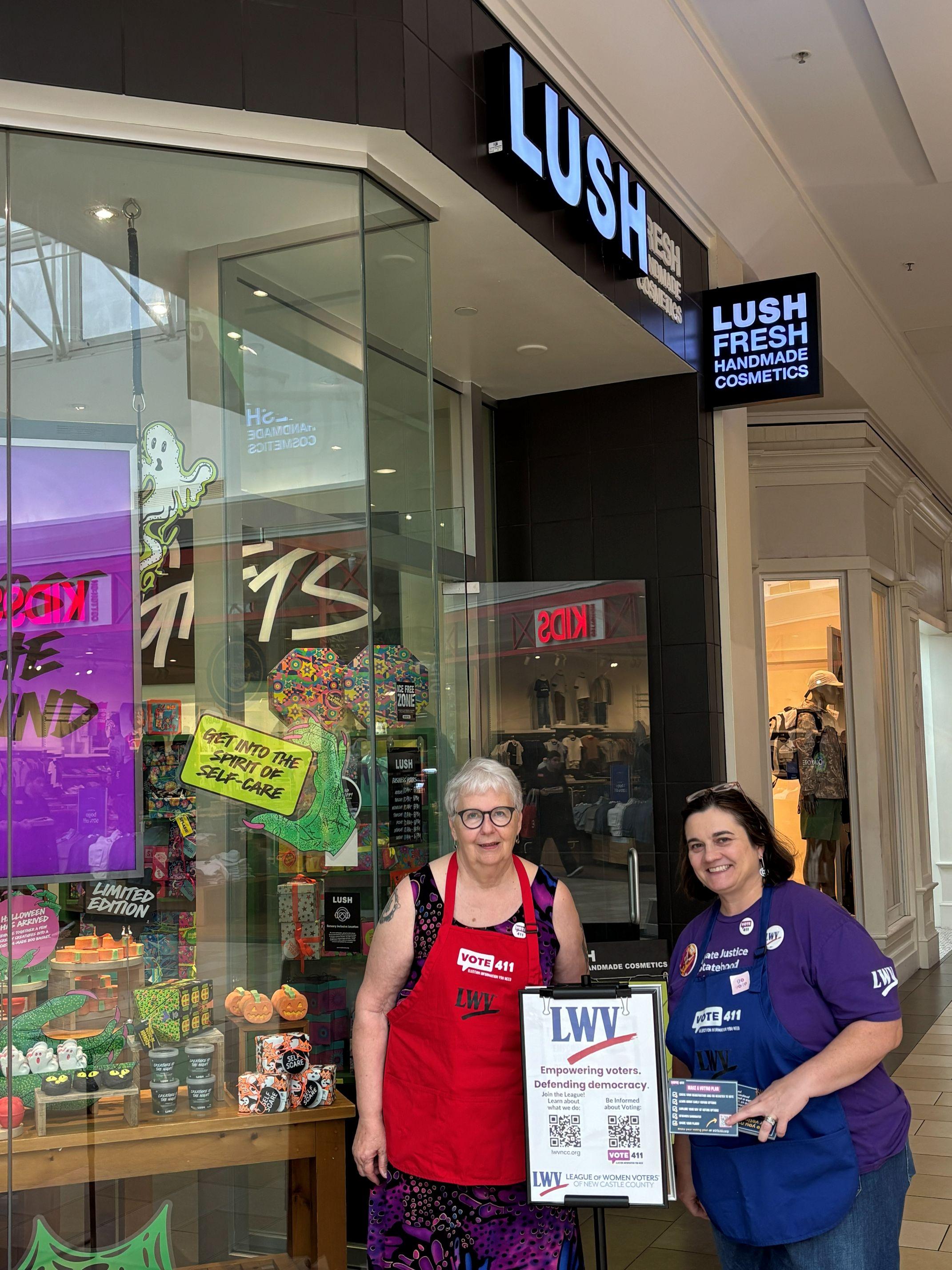 Susan and Tiffany are shown with LUSH and LWV signage at an August 2026 voter outreach event