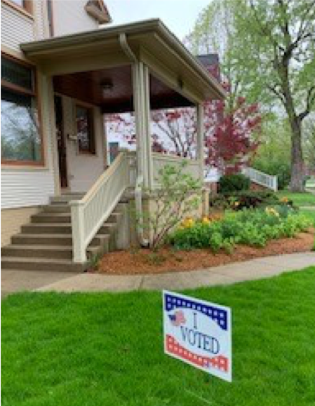 Show your neighbors you voted with our "I Voted" sign! A house with lawn has a "I Voted" sign out front.