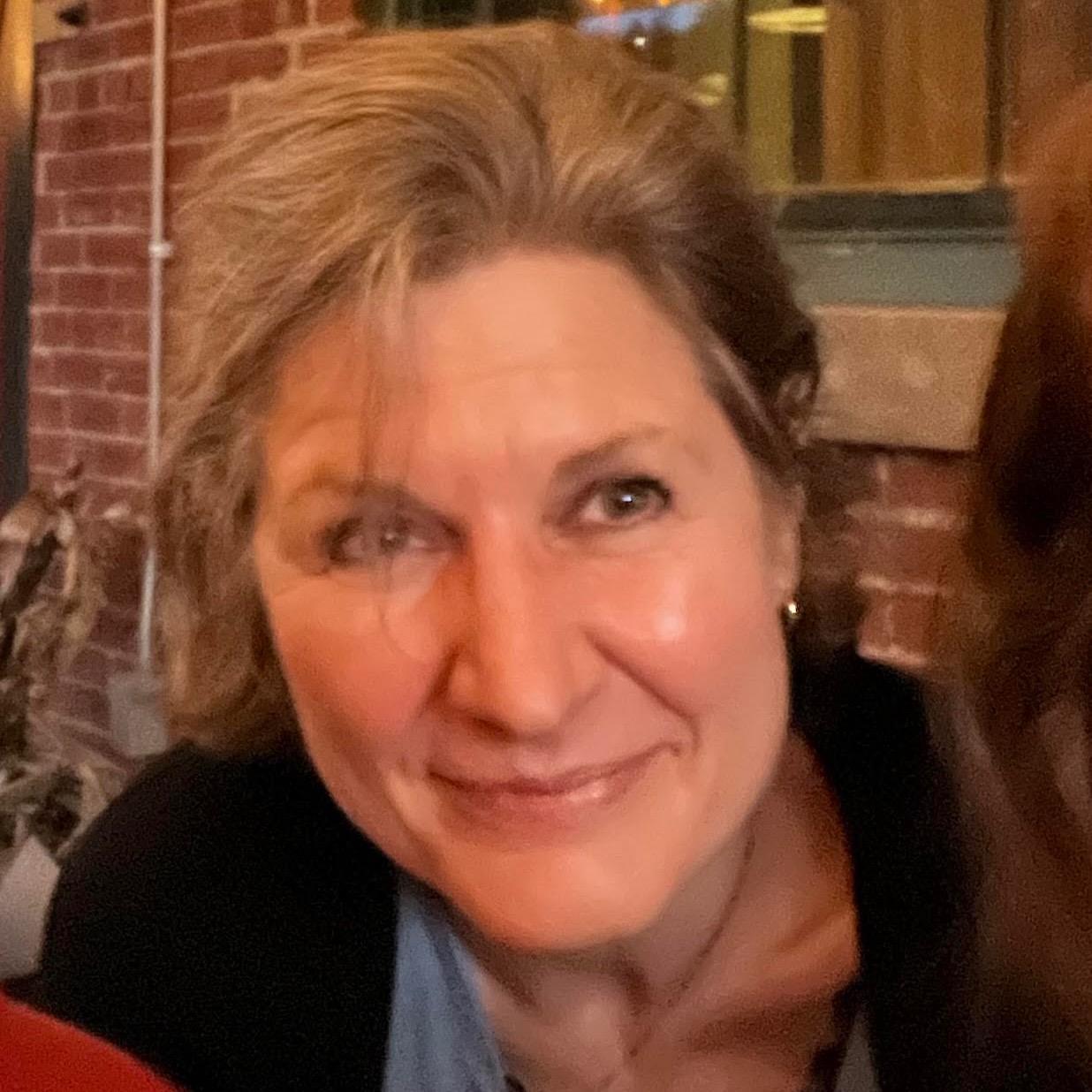 Close up head shot of smiling woman with light brown hair