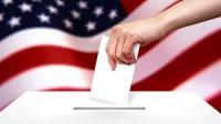 Voter casting vote into Ballot box (USA flag background)