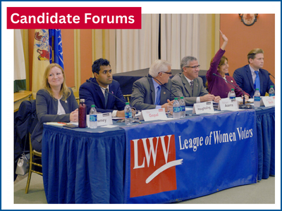 Candidate Forums - candidates sitting at table on dais with LWV logo