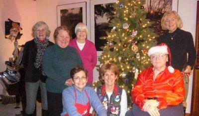 Members gather around Christmas tree at party