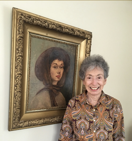 Woman standing next to a painting of a woman