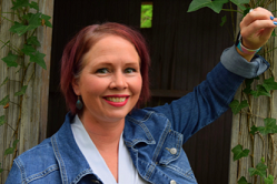 Woman in jean jacket smiles at camera
