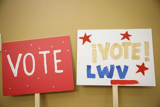 two hand drawn signs the first says VOTE and the second says !VOTE! LWV