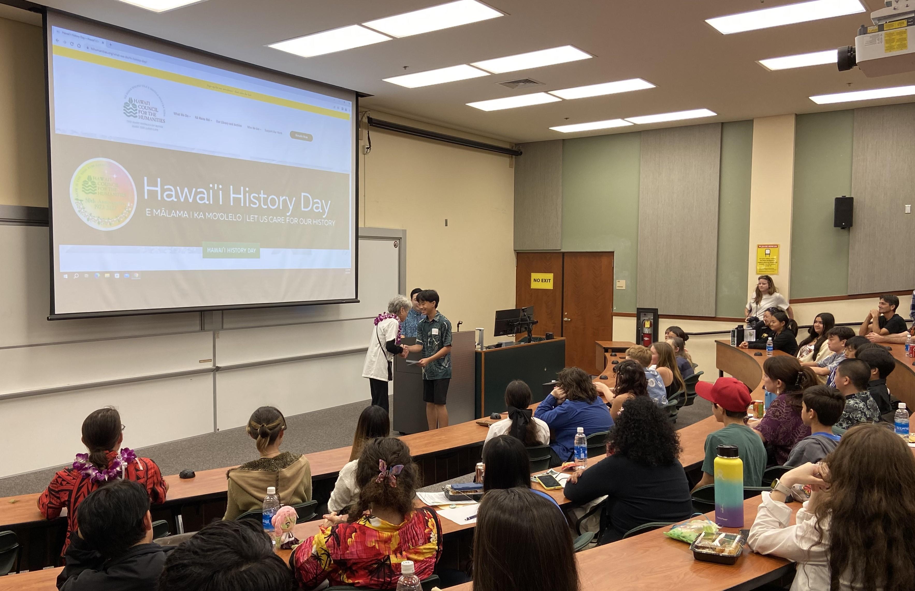 LWVHC Member Nina Buchanan presenting the League's award for outstanding student project at Hawai'i History Day.
