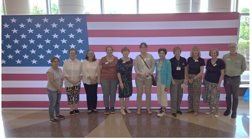 Large voter registration team in front of wall-size American flag at Lindenwood
