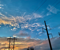 Sunset sky with power lines and power poles in foreground