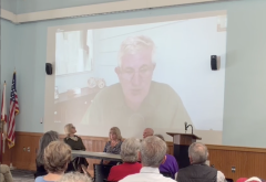 screen shot of live presentation with man on screen and people watching