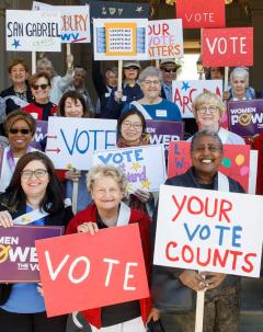 women holding signs that say vote