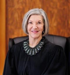 Judge Flottman Woman in black judicial robe smiles at camera